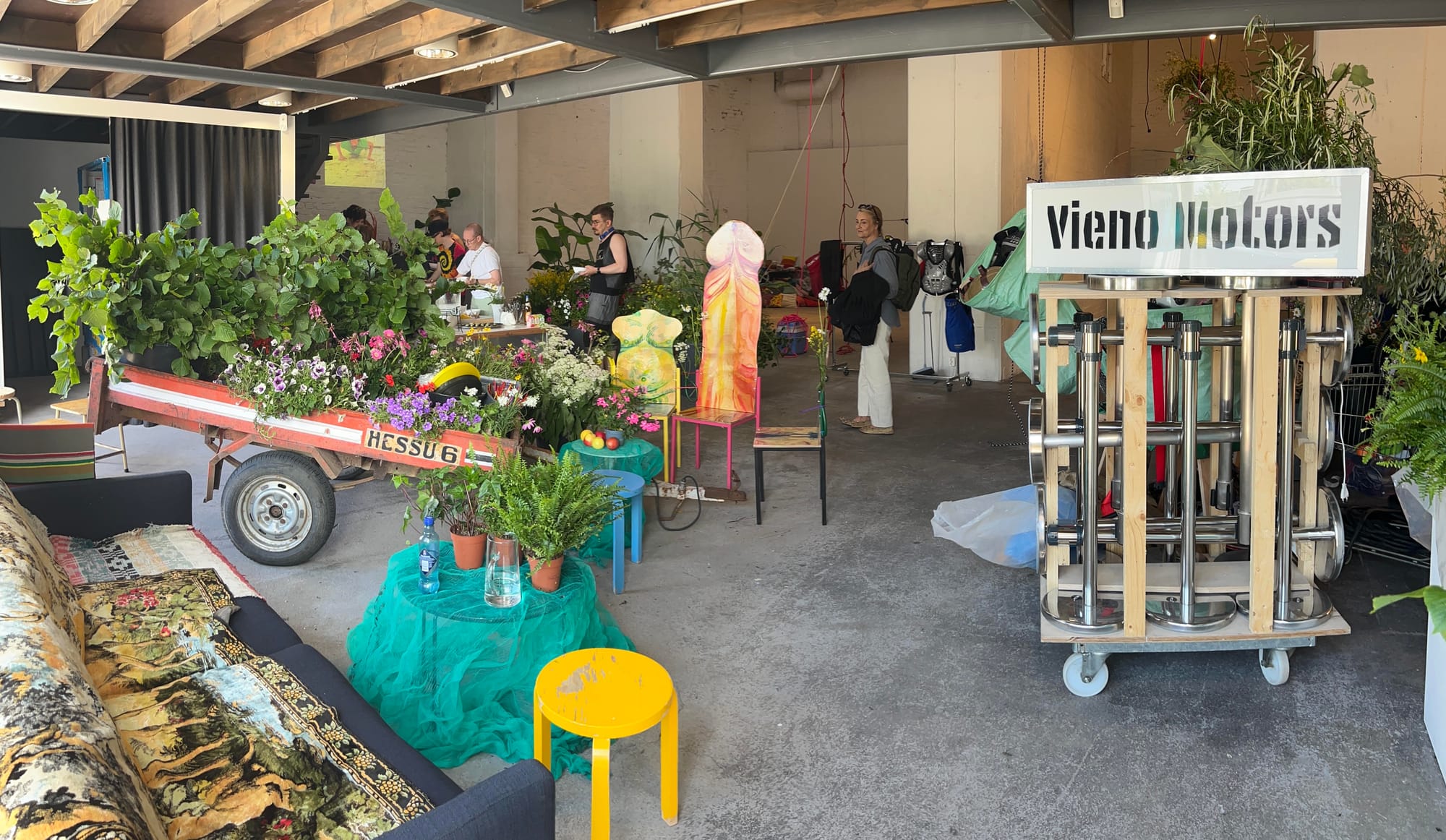 Vieno Motors-installationen på Forum Box: ett släp fyllt av växter, vagnen med Vieno Motors-skylten, soffa och stolar.